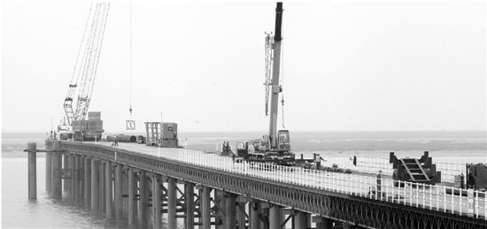 昨天，在寧?？h三門灣跨海大橋海上建設工地，工人們正在連接長40米的鋼管樁，為建造橋墩作準備。目前，概算投資126億元的三門灣跨海大橋及接線工程前期施工進展順利，將于下月起全面進入海上、全線隧道、樁基、路基工程建設。